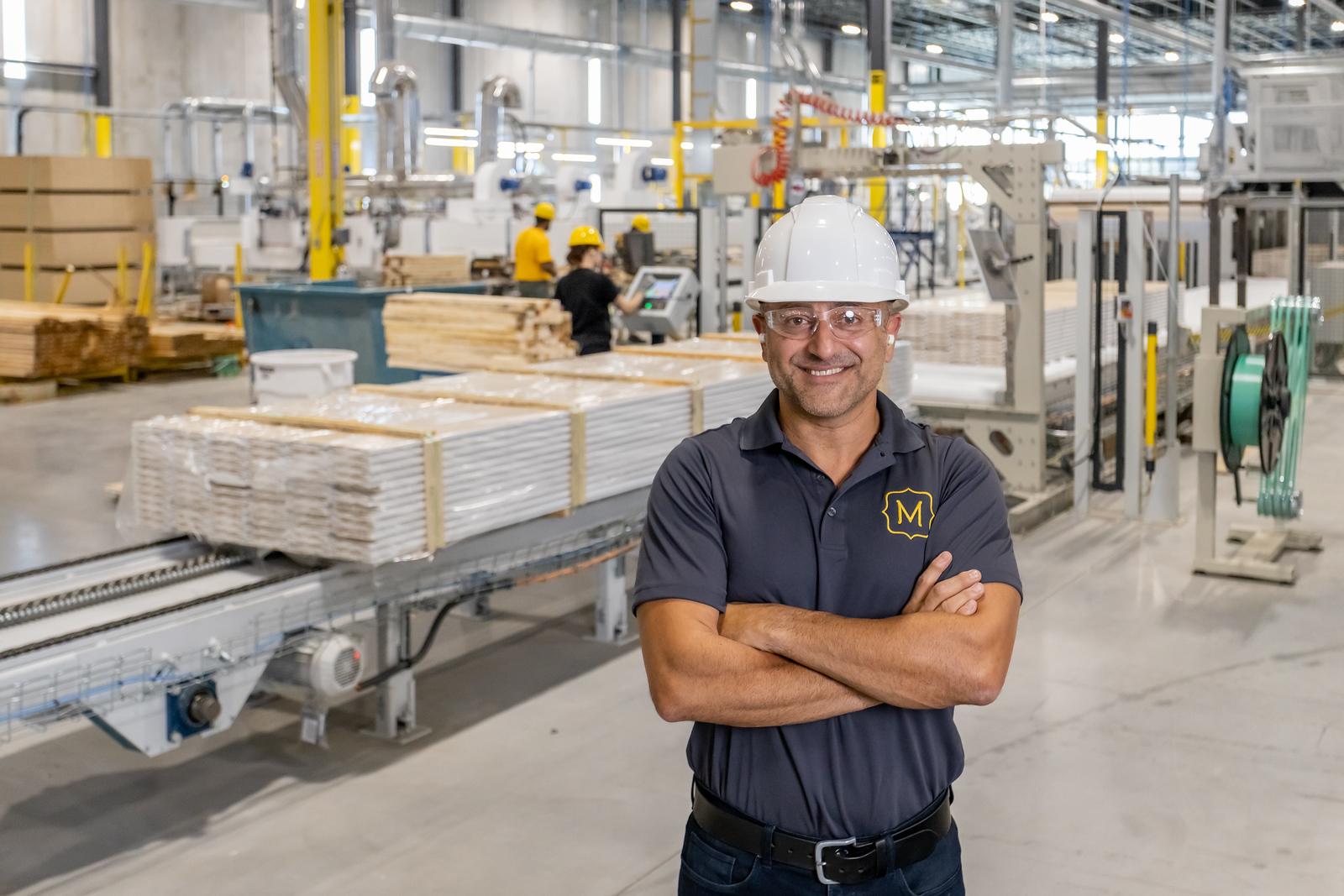 Metrie employee with white hard hat in our manufacturing facility