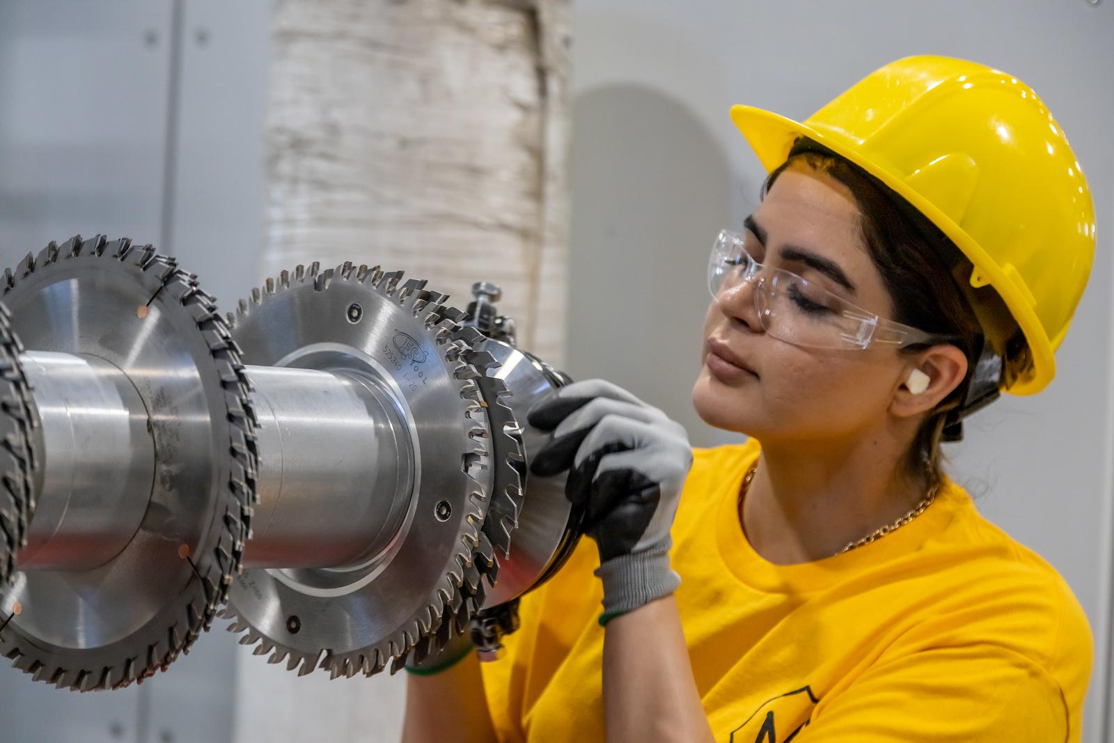 Women in hard hat at Metrie working on the mill manufacturing MDF